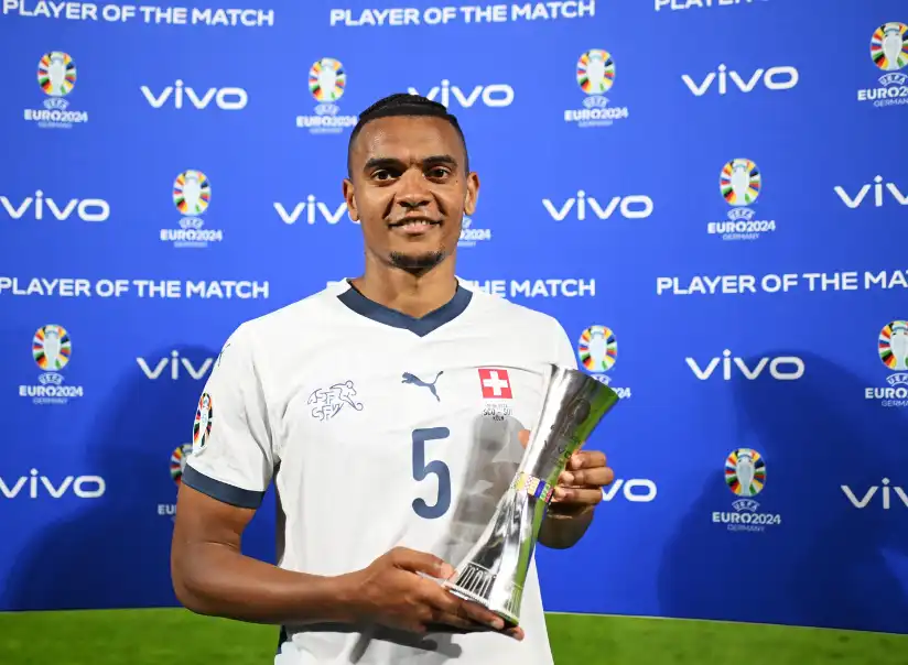 瑞士國家隊球員曼努埃爾·阿坎吉(Manuel Akanji)身穿瑞士白色球衣,於 UEFA EURO 2026 賽後手持單場最佳球員獎盃拍照。
