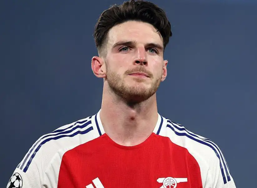 德克蘭·賴斯(Declan Rice)身穿阿森納紅白球衣,在比賽場邊注視前方。